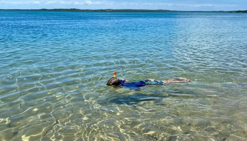 A child enjoying a snorkelling experience in the blue ocean waters of Mozambique