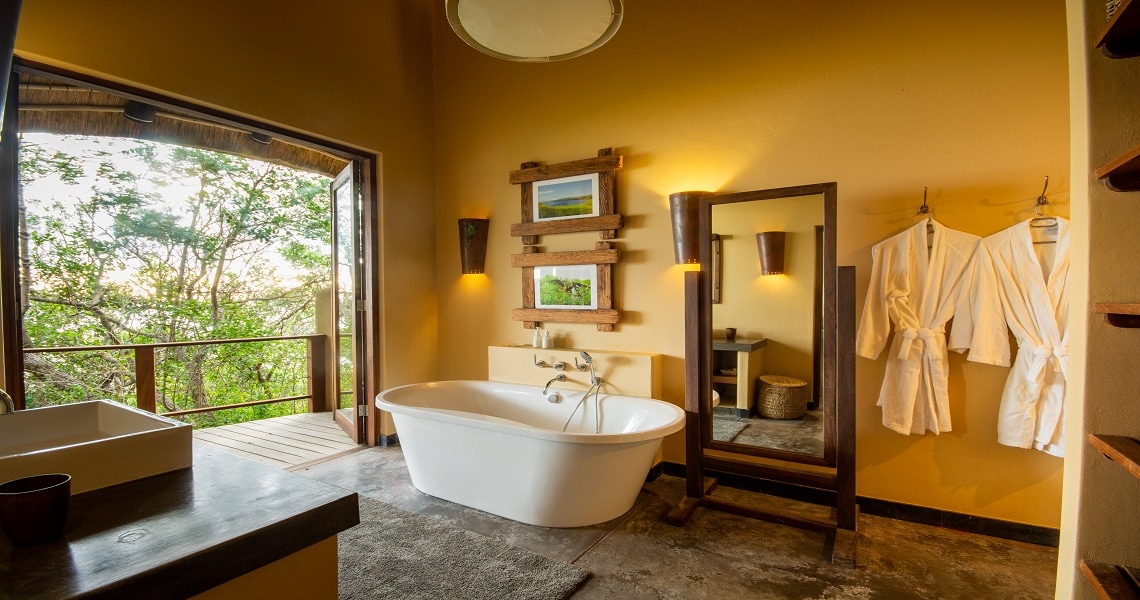 Luxurious suite with a bathtub, complemented with a scenic view overlooking the bush